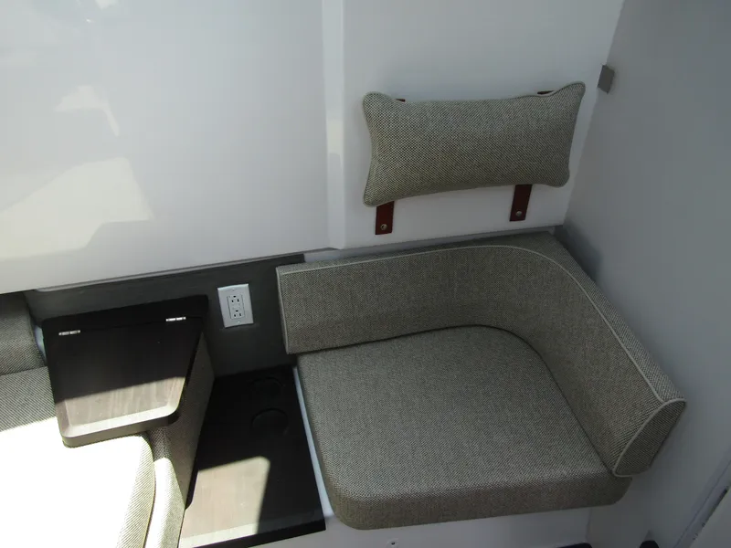 Slide: The Image of 2024 Axopar 37XC Cross Cabin interior seating with cushion and power outlet. - 28