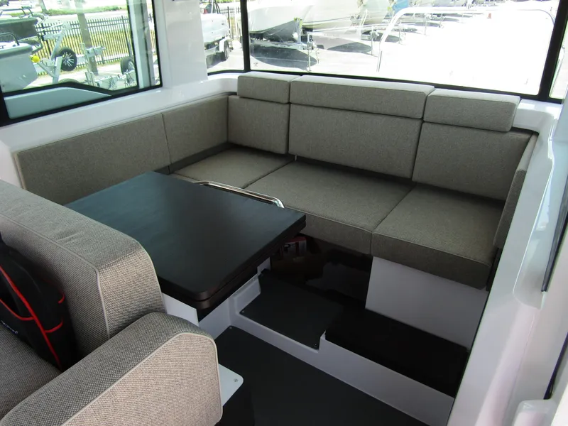 Slide: The Image of Interior seating area of 2024 Axopar 37XC CROSS CABIN with grey upholstery and black table. - 29