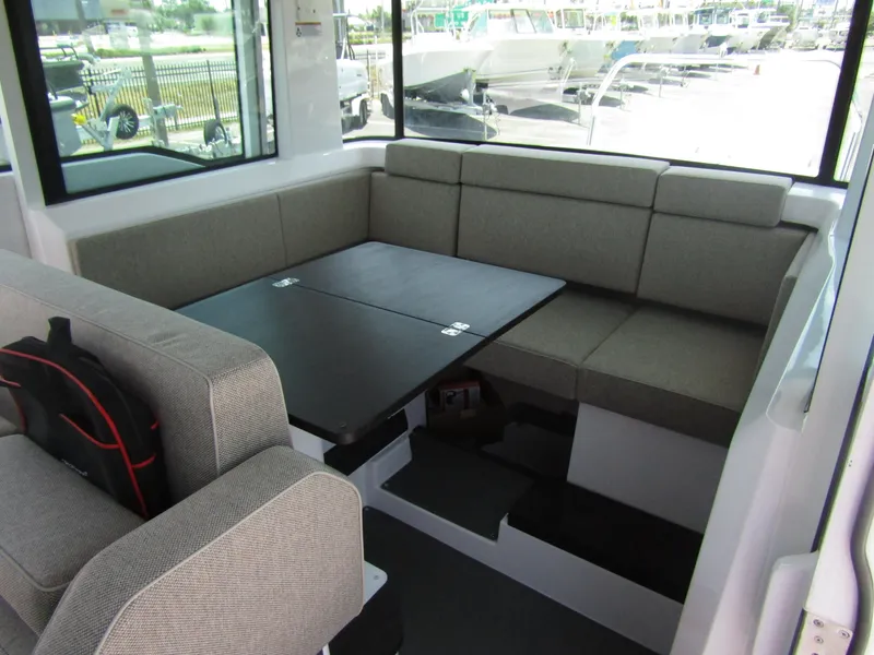 Slide: The Image of Interior seating area of 2024 Axopar 37XC CROSS CABIN with grey upholstery and foldable table. - 30