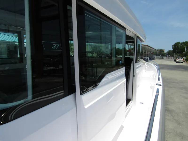 Slide: The Image of 2024 Axopar 37XC CROSS CABIN side view with windows and sleek white exterior. - 37