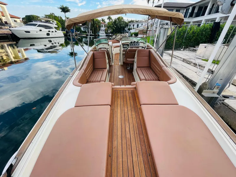 Slide: The Image of 2014 Chris-Craft Launch 32 boat with tan upholstery and wooden deck, docked in a marina. - 6