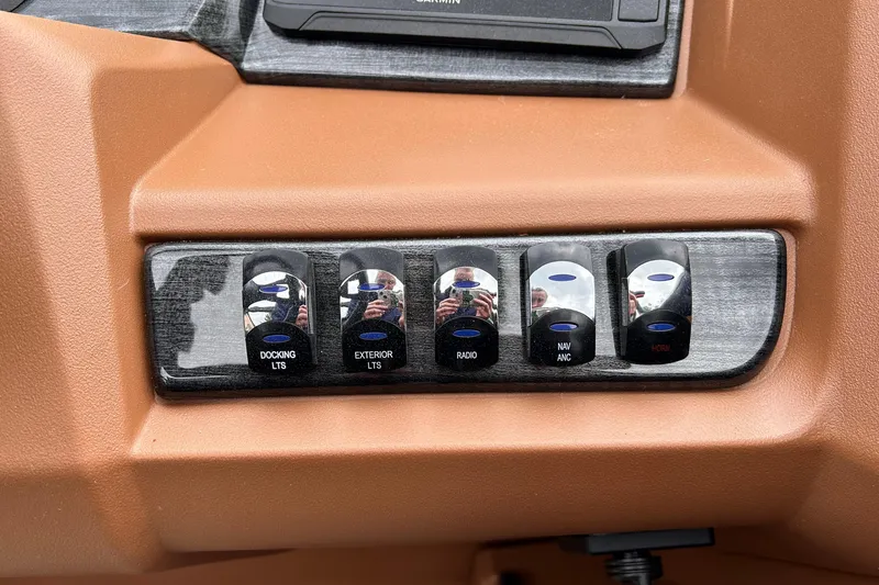 Slide: The Image of Control panel of 2024 Avalon LSZ Entertainer 23' boat with labeled switches. - 12