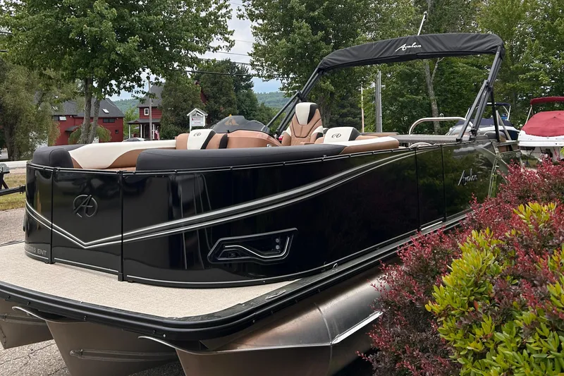 Slide: The Image of 2024 Avalon LSZ Entertainer 23' pontoon boat in a scenic outdoor setting. - 2