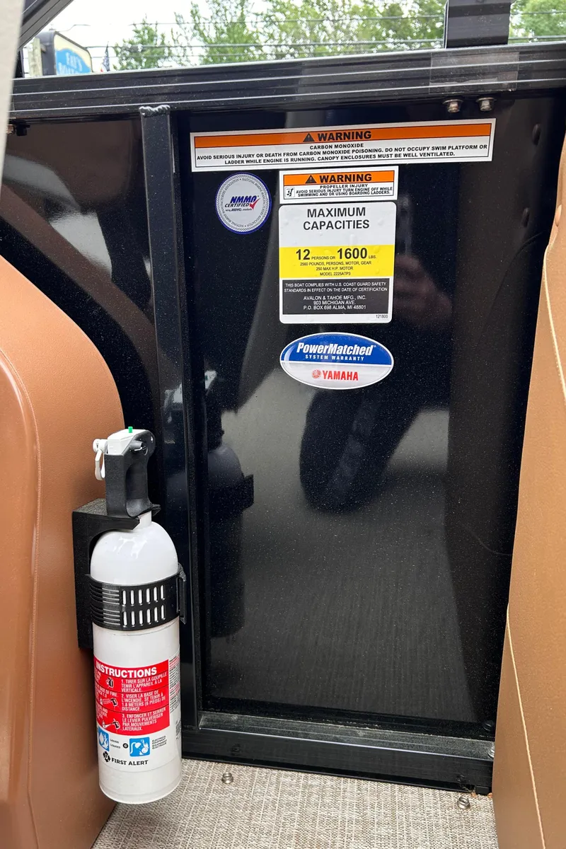 Slide: The Image of 2024 Avalon LSZ Entertainer 23' boat capacity label and fire extinguisher. - 28