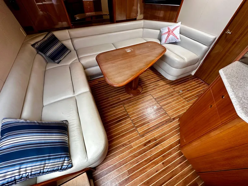 Slide: The Image of 2005 Viking 45 Open Express yacht interior with L-shaped seating and wooden table. - 39