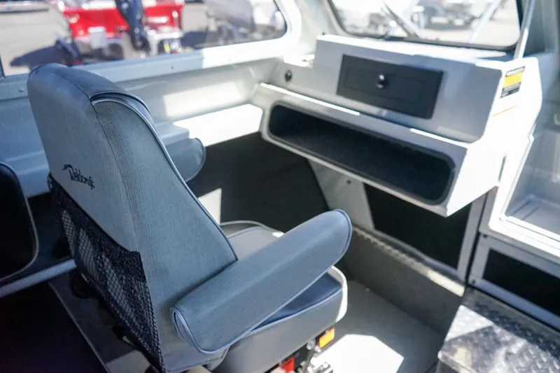 Slide: The Image of Interior of 2025 Weldcraft 240 Ocean King boat with captain's chair and dashboard. - 11