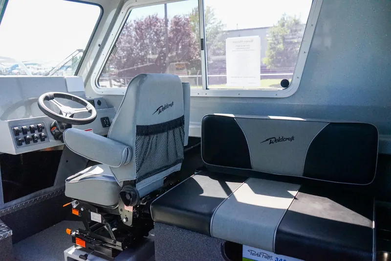 Slide: The Image of Interior of 2025 Weldcraft 240 Ocean King boat with steering wheel and seating. - 4