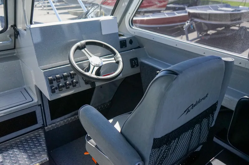 Slide: The Image of Interior cockpit of 2025 Weldcraft 240 Ocean King boat with steering wheel and control panel. - 9