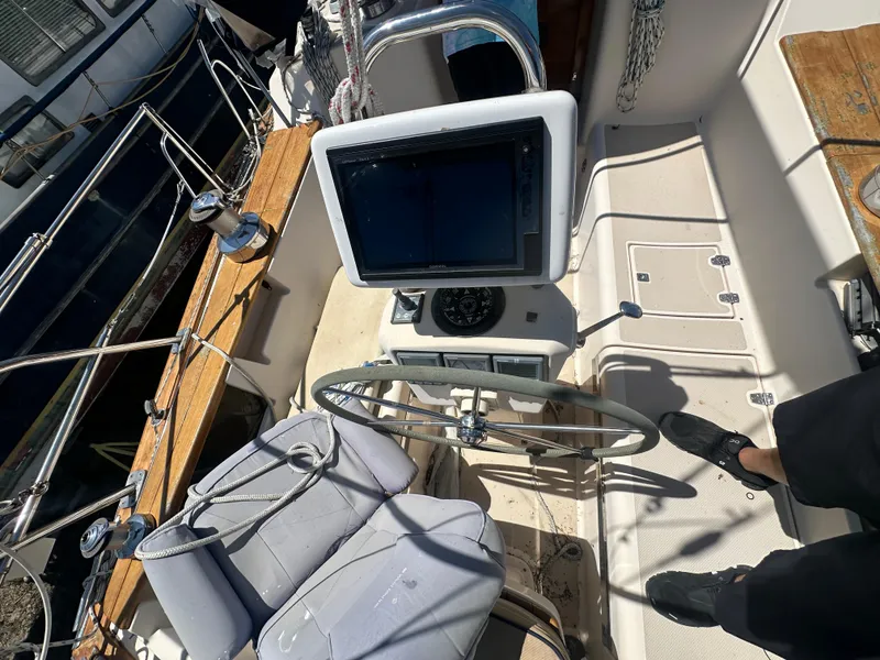 Slide: The Image of Cockpit of a 2002 Island Packet 420 sailboat with steering wheel and navigation equipment. - 16