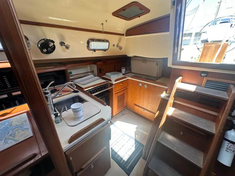 Slide: The Image of Interior of 2002 Island Packet 420 sailboat with kitchen and stairs to deck. - 21