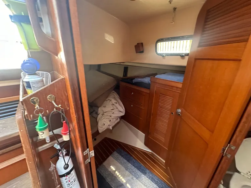 Slide: The Image of 2002 Island Packet 420 cabin interior with wooden furnishings and cozy sleeping area. - 22