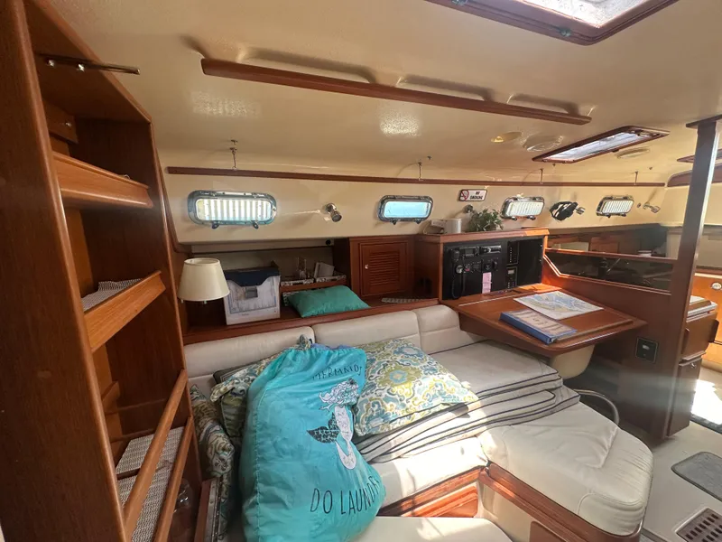 Slide: The Image of Interior of 2002 Island Packet 420 sailboat with cozy seating and wooden cabinetry. - 27