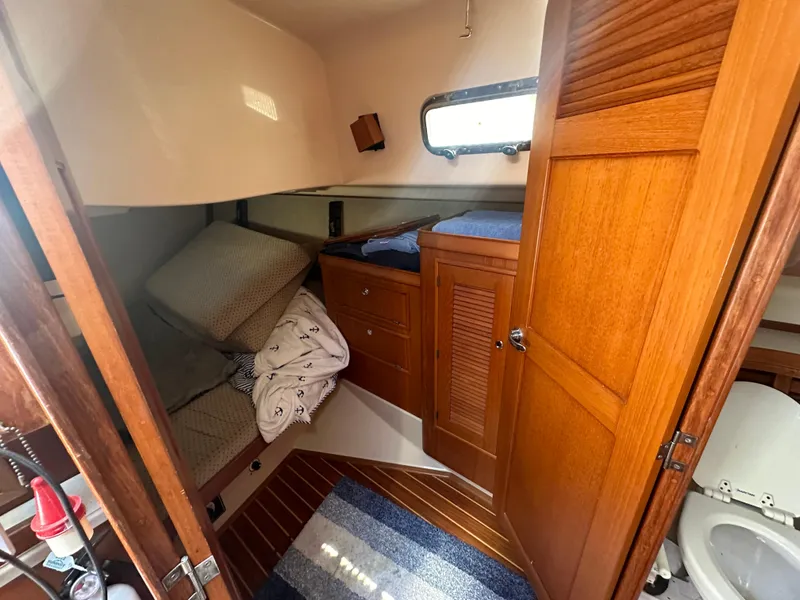 Slide: The Image of 2002 Island Packet 420 cabin interior with wooden cabinetry and cozy sleeping area. - 29