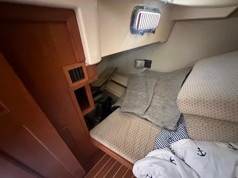 Slide: The Image of Cozy cabin interior of 2002 Island Packet 420 sailboat with wooden accents and bedding. - 30