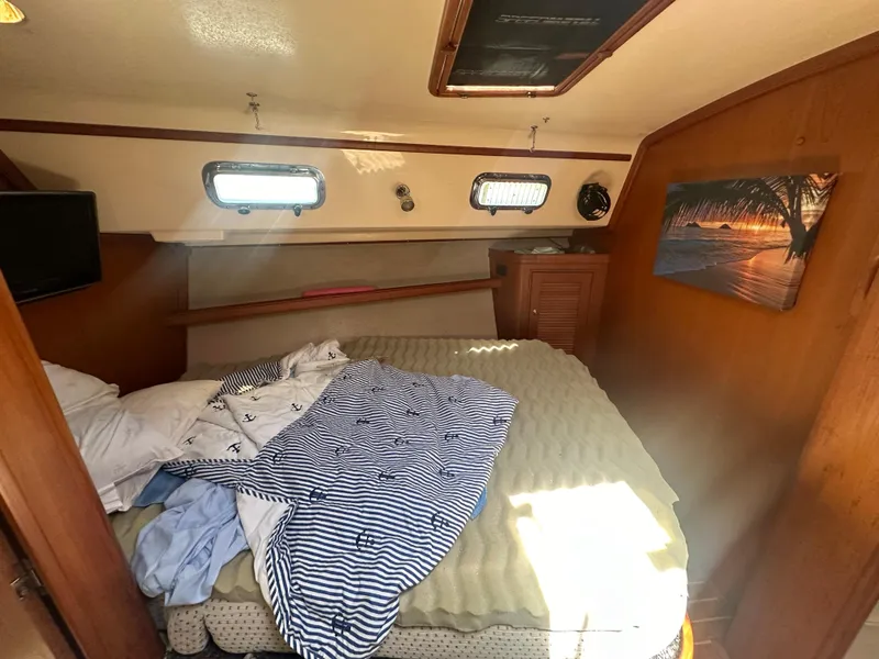 Slide: The Image of Island Packet 420 2002 sailboat cabin with bed, portholes, and wall art. - 35