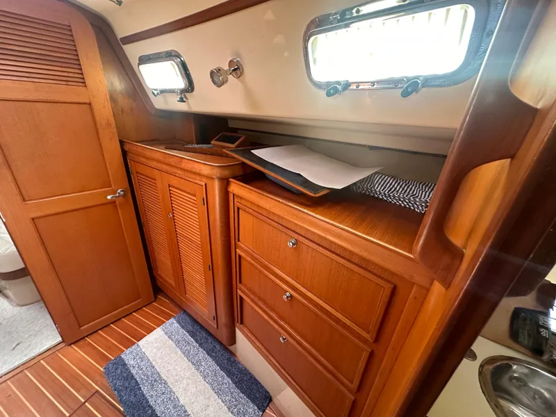 Slide: The Image of Interior of 2002 Island Packet 420 sailboat with wooden cabinets and drawers. - 44
