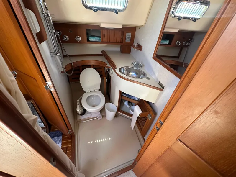 Slide: The Image of Island Packet 420 2002 yacht bathroom with toilet, sink, and wooden cabinetry. - 45