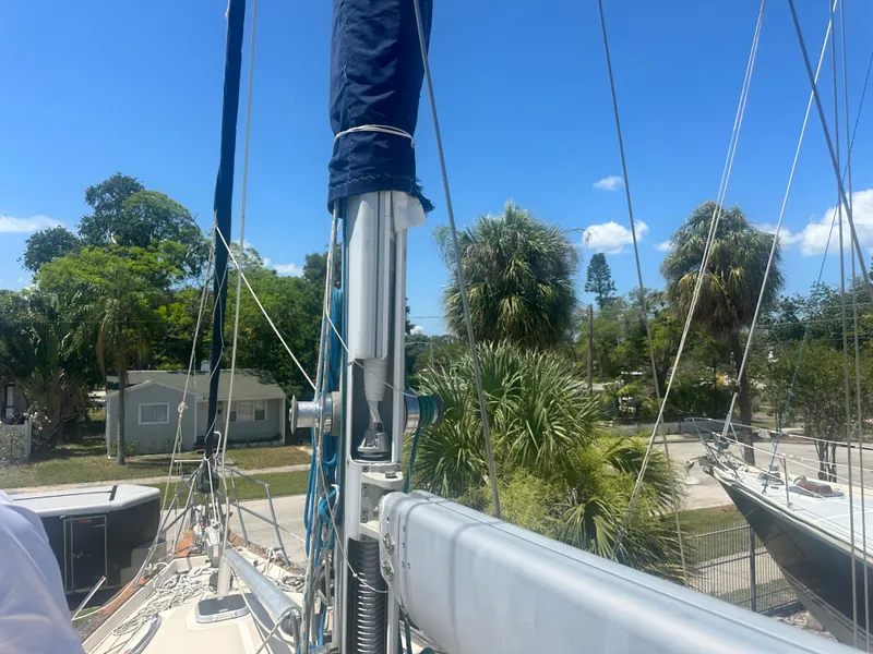 Slide: The Image of Island Packet 420 sailboat from 2002 docked, surrounded by lush greenery and clear blue skies. - 8