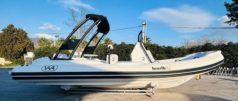 Slide: The Image of 2025 Aqvaboats Luxrib 22 inflatable boat with black arch, parked on a trailer. - 15