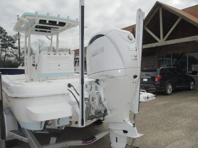 Slide: The Image of 2025 Caymas 26HB boat with powerful outboard motor, parked outdoors. - 8