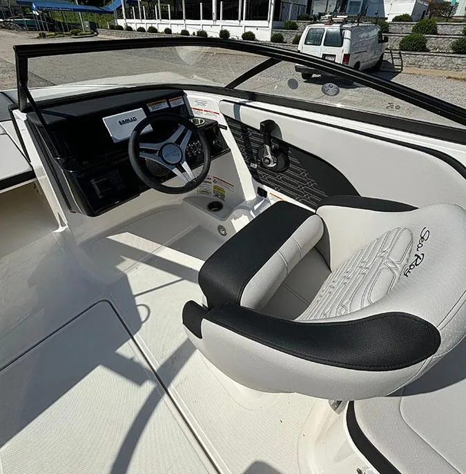 Slide: The Image of 2024 Sea Ray SPX 210 boat interior with steering wheel and captain's chair. - 11