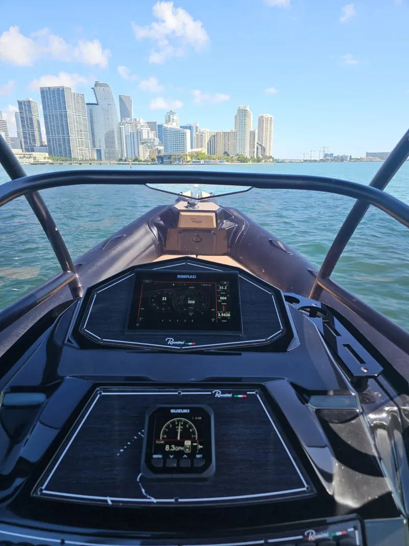 Slide: The Image of View from the helm of a 2023 Ranieri CAYMAN 26 SPORT TOURING boat with city skyline. - 19