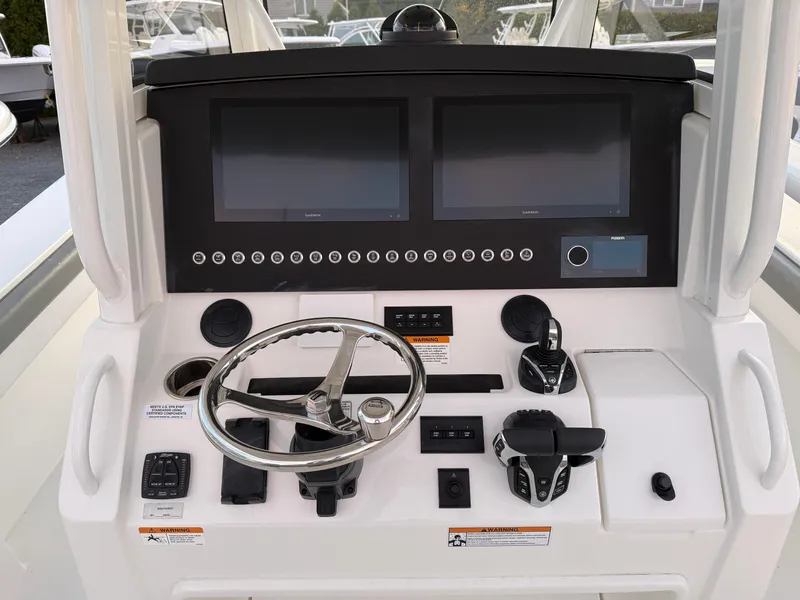 Slide: The Image of 2024 Regulator 34 boat dashboard with dual screens and steering wheel. - 4