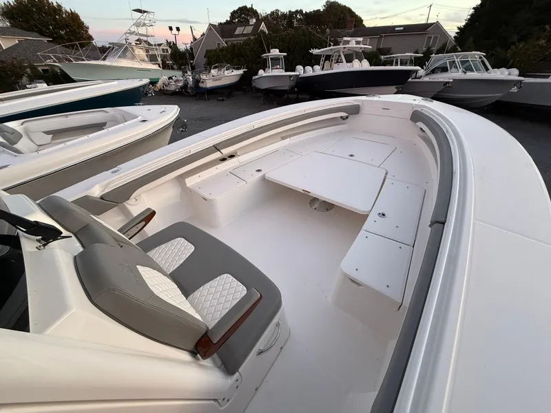 Slide: The Image of 2024 Regulator 34 boat with spacious seating and sleek design in a marina setting. - 5