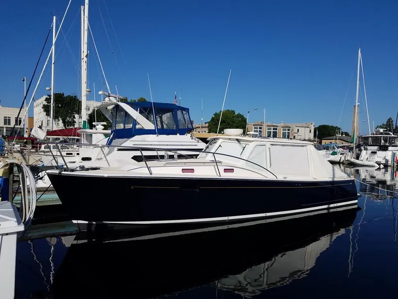 Slide: The Image of 2013 MJM 36z Downeast boat docked in a marina under clear blue skies. - 2
