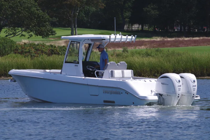 Slide: The Image of 2025 Everglades 285 Center Console boat cruising on a calm lake. - 3
