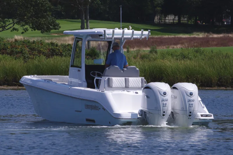 Slide: The Image of 2025 Everglades 285 Center Console boat cruising on a calm lake. - 4
