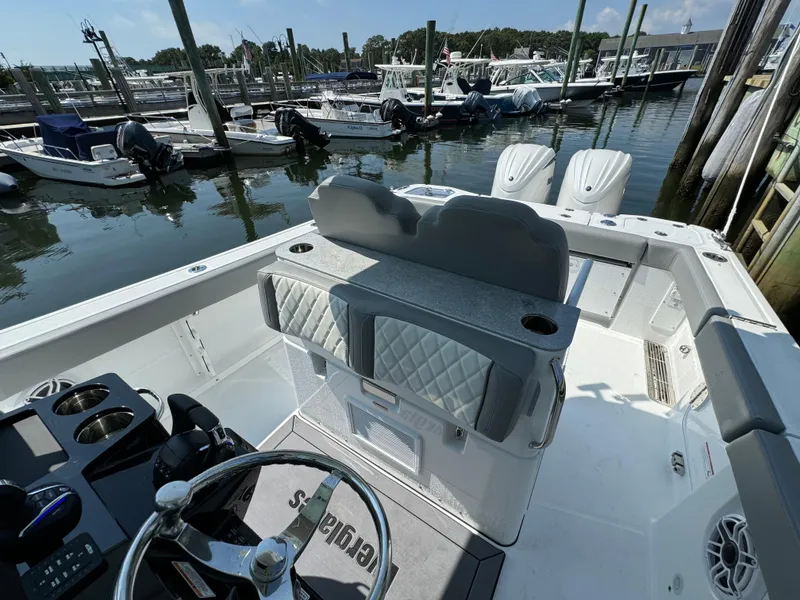 Slide: The Image of 2025 Everglades 285 Center Console boat interior at marina, featuring helm and seating. - 49