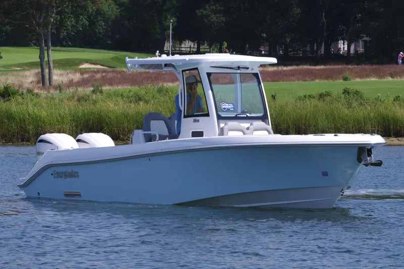 Slide: The Image of 2025 Everglades 285 Center Console boat on calm water, surrounded by greenery. - 9