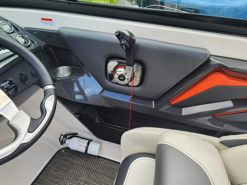 Slide: The Image of 2014 Monterey 234 Super Sport boat interior, showing steering wheel, throttle control, and fire extinguisher. - 10