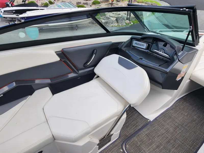 Slide: The Image of 2014 Monterey 234 Super Sport boat interior with white seating and Fusion stereo system. - 14