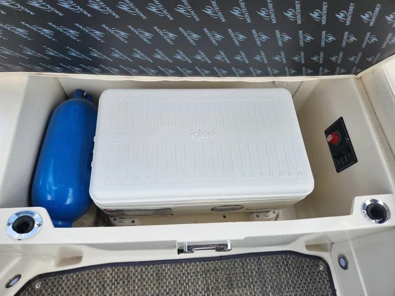 Slide: The Image of Storage compartment of a 2014 Monterey 234 Super Sport boat with cooler and blue fender. - 5