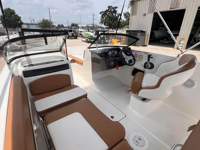 Slide: The Image of 2021 Bayliner VR5 Bowrider I/O interior with tan and white seating, steering console, and open deck. - 13