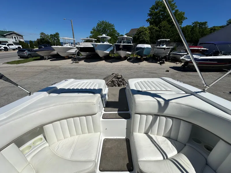 Slide: The Image of 2003 Cobalt 262 boat interior with white seating, parked among other boats. - 16