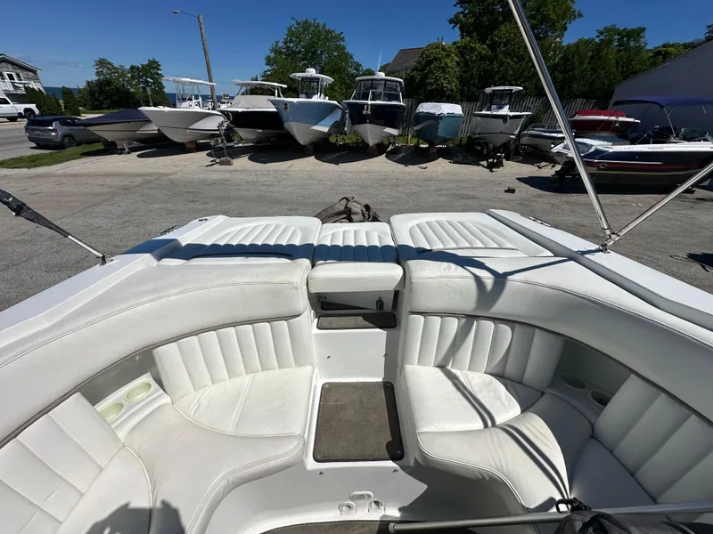 Slide: The Image of 2003 Cobalt 262 boat with white leather seating, docked among other boats. - 17