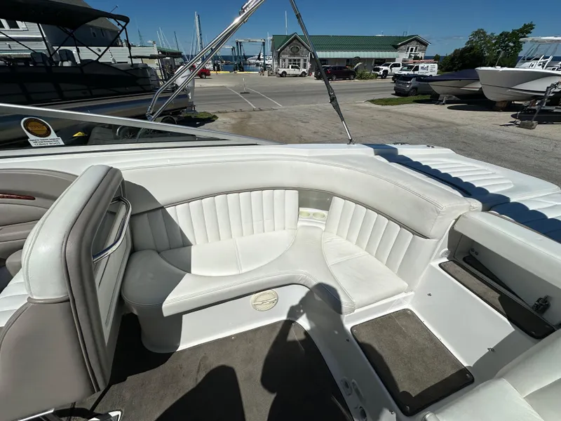 Slide: The Image of 2003 Cobalt 262 boat with white leather seating and spacious deck at a marina. - 18
