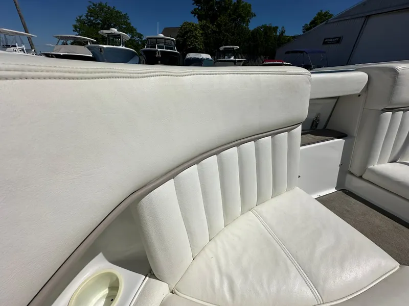 Slide: The Image of 2003 Cobalt 262 boat with white leather seating in a marina. - 19