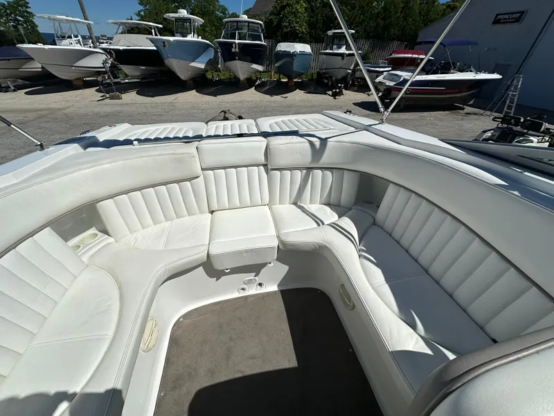 Slide: The Image of 2003 Cobalt 262 boat with white leather seating in a marina. - 21