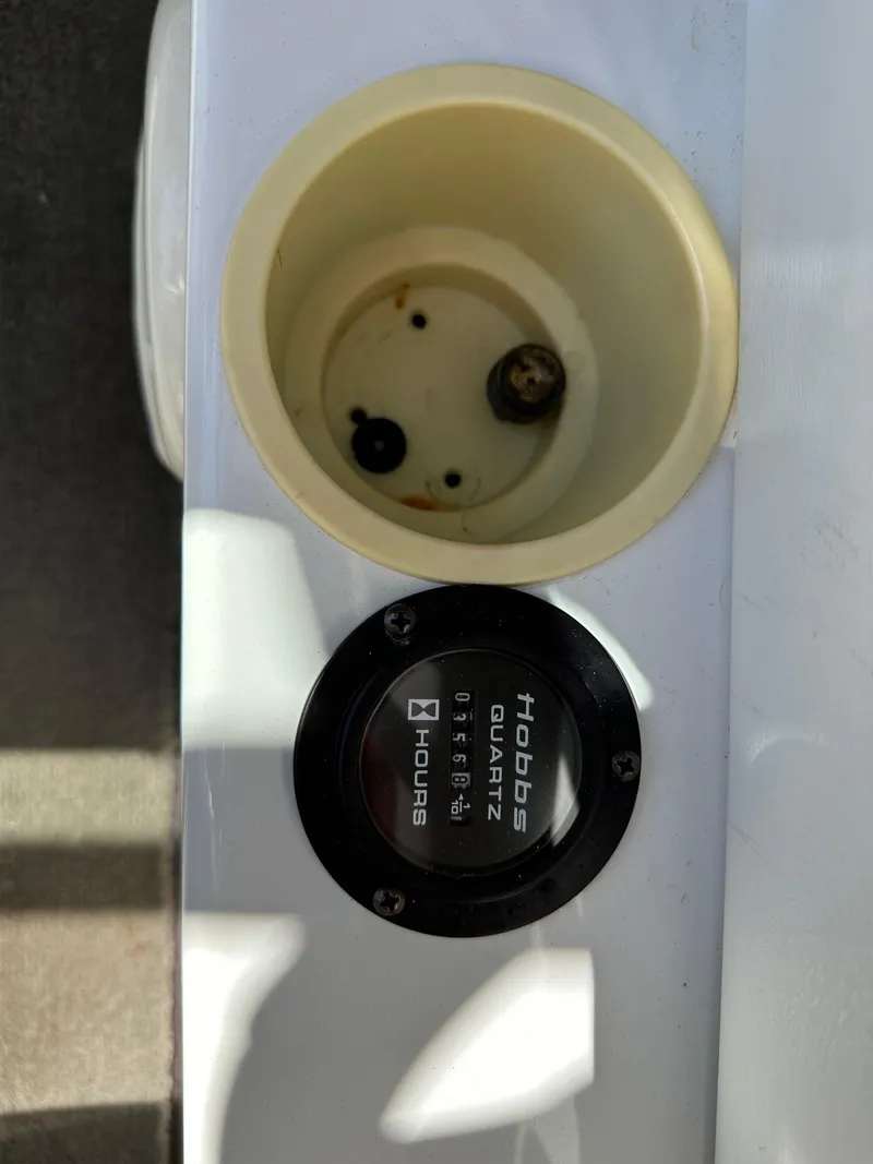 Slide: The Image of Hour meter and empty cup holder on a 2003 Cobalt 262 boat. - 28