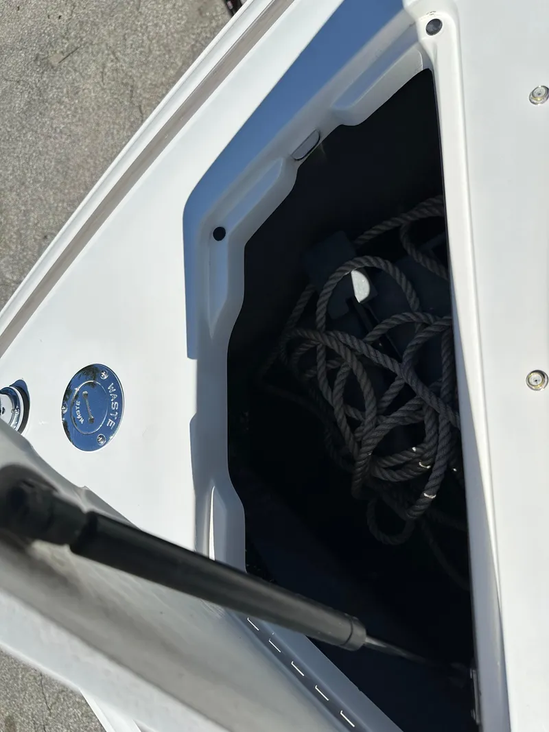 Slide: The Image of Open storage compartment on a 2003 Cobalt 262 boat with coiled rope inside. - 37