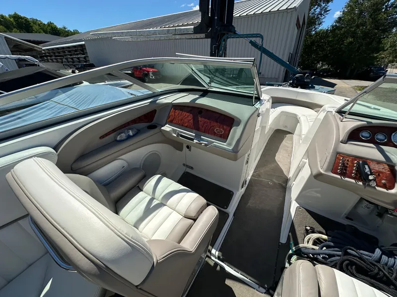 Slide: The Image of 2003 Cobalt 262 boat interior with white and beige seating, dashboard, and steering wheel. - 44