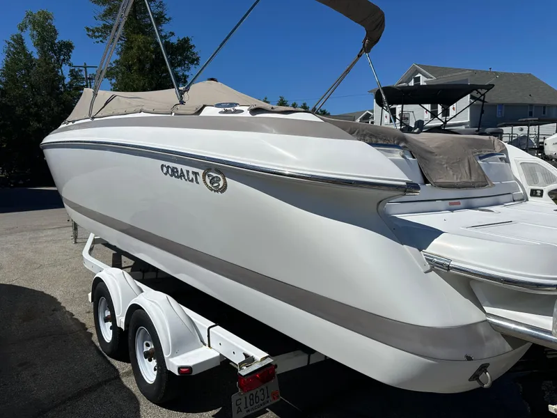 Slide: The Image of 2003 Cobalt 262 boat on a trailer, covered and parked outdoors. - 8
