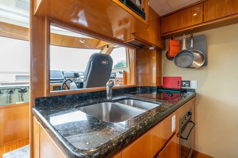 Slide: The Image of Luxurious kitchen in 1999 Vitech 68' Pilothouse yacht with granite countertops and modern appliances. - 15