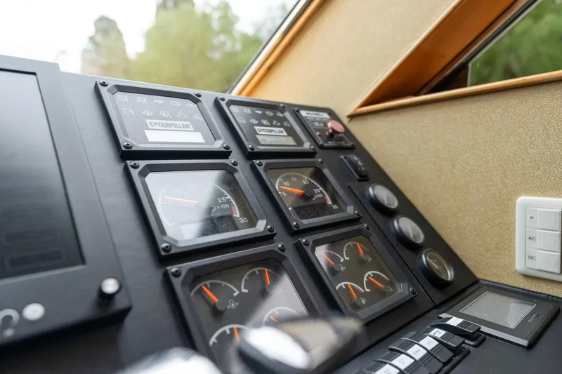 Slide: The Image of Control panel of a 1999 Vitech 68' Pilothouse yacht, featuring gauges and switches. - 23