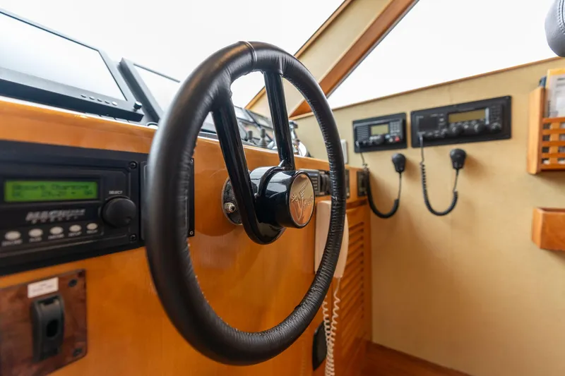 Slide: The Image of Pilothouse interior of 1999 Vitech 68' yacht, featuring steering wheel and navigation controls. - 25