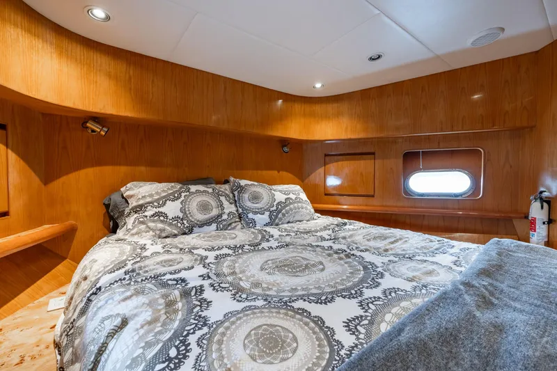 Slide: The Image of Luxurious bedroom in 1999 Vitech 68' Pilothouse yacht with elegant bedding and wood paneling. - 35